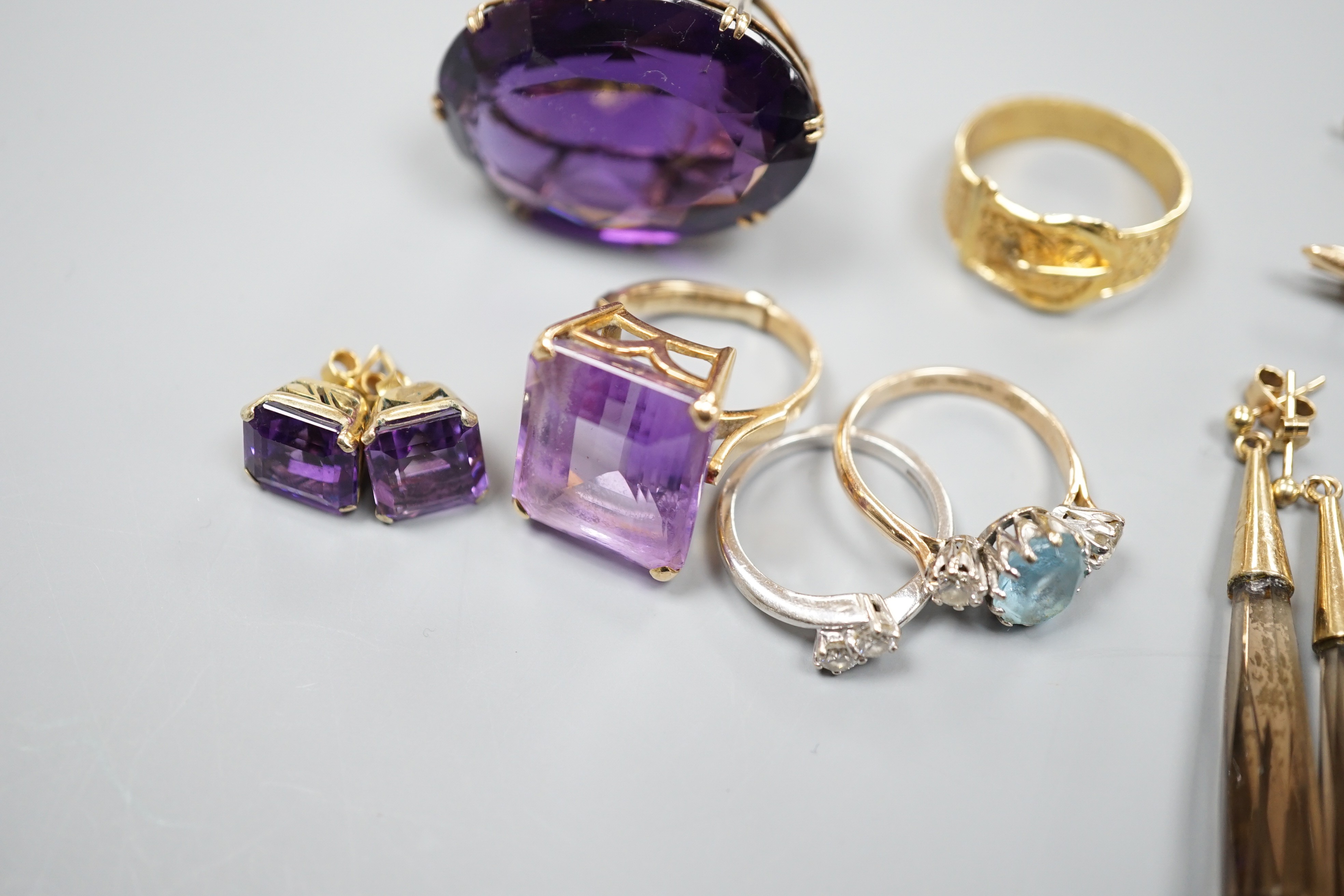 A large 9ct and oval cut amethyst dress ring, size L, three other rings including a 9ct gold buckle ring, an 18ct white gold and two stone crossover ring, two gem set bar brooches including 15ct and three assorted pairs